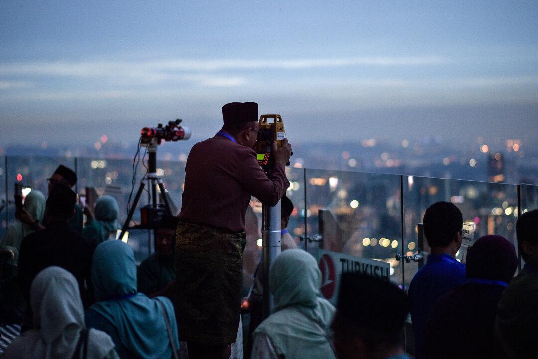 Malaysia's religious department member uses a telescope to perform “Rukyah,” the sighting of the new moon to mark the start of Islam's holy month of Ramadan in Kuala Lumpur, Malaysia, on Feb. 17, 2026. (Arif Kartono/AFP via Getty Images)