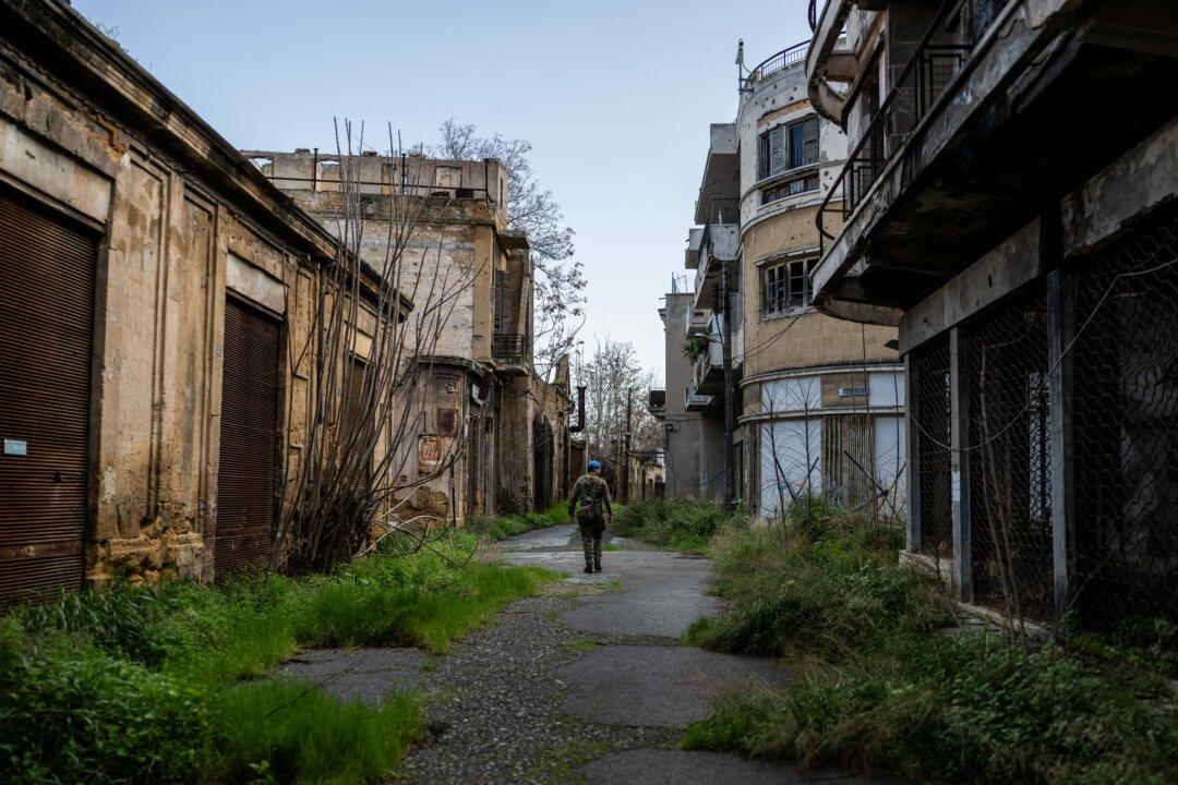 Captain Alexander Lowe of the United Nations Peacekeeping Force in Cyprus (UNFICYP), from the British Army's 1st Battalion Coldstream Guards, No. 2 Company, patrols in the buffer zone in the divided capital Nicosia, on Feb. 17, 2026. Cyprus has been divided since 1974, when a Turkish invasion followed a coup in Nicosia backed by Greece's then military junta. There are currently nine crossings along the UN-patrolled Green Line separating the two sides, and calls have grown for additional crossings along the 110-mile buffer zone. (Jewel Samad/AFP via Getty Images)