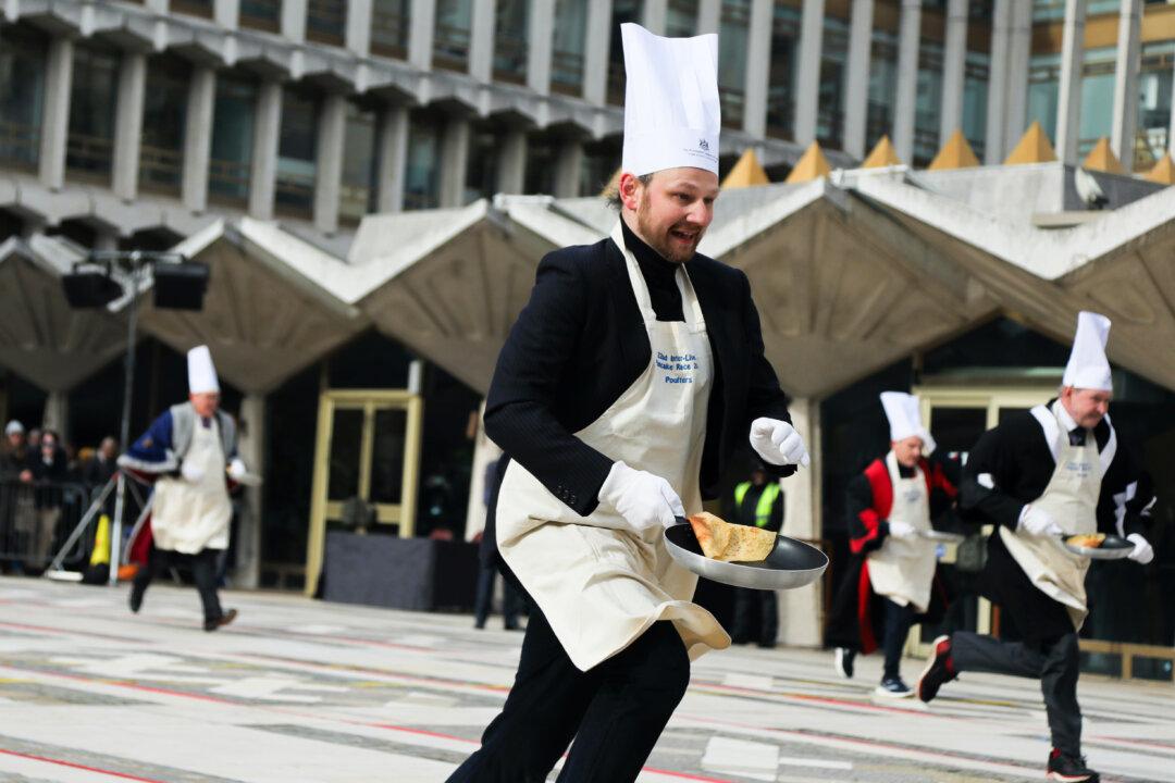 Competitors take part in the annual Inter-Livery Pancake Race at The Guildhall in London, on Feb. 17, 2026. The annual event sees teams from historic livery companies participate in a Shrove Tuesday pancake-tossing race, while dressed in ceremonial robes or novelty costumes. (Alishia Abodunde/Getty Images)