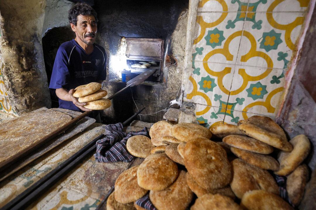 A baker prepares traditional Moroccan white bread, or “khobz,” in a wood-fired oven at a bakery in Rabat, Morocco, on Feb. 17, 2026. (Abdel Majid Bziouat/AFP via Getty Images)