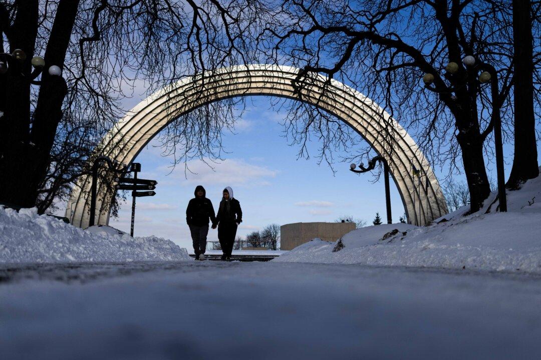 A couple walk in front of the Arch of Freedom of the Ukrainian People in Kyiv, on Feb. 17, 2026, amid the Russian invasion of Ukraine. (Henry Nicholls/AFP via Getty Images)