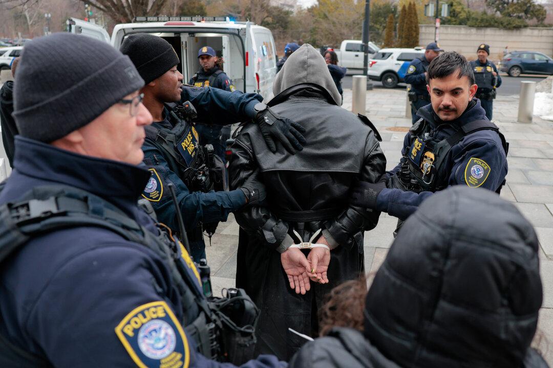 Protesters are arrested during a demonstration with Gender Liberation Movement and ACT UP blocking the entrance to the Department of Health and Human Services in Washington on Feb. 17, 2026. The were 24 arrests on the final day of public comment over proposed rules that critics say would effectively ban “gender-affirming care” for transgender youth nationally. (Heather Diehl/Getty Images)