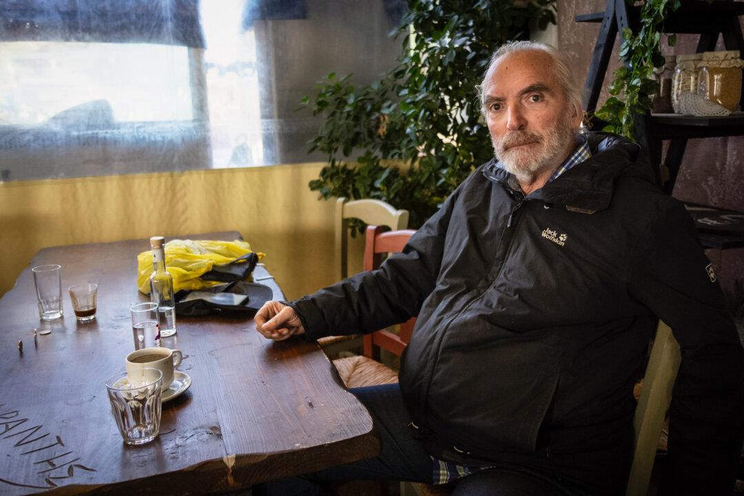 Nikos Mixalakis enjoys a cafe in Volissos, Greece, on Nov. 14, 2025. Mixalakis said he was frustrated by the lack of information about potential health impacts from toxic exposure. (John Fredricks/The Epoch Times)