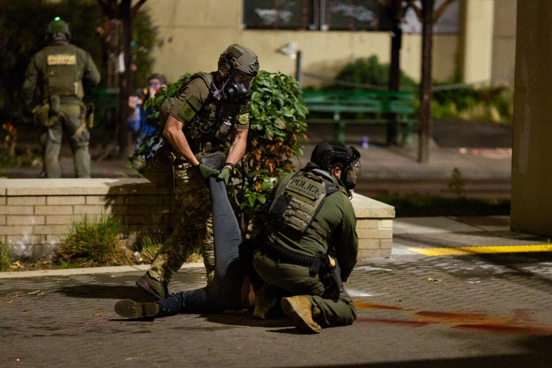 A protester is arrested outside Immigration and Customs Enforcement (ICE) offices in Portland, Ore., on Oct. 4, 2025. Violent attacks against ICE officers in Portland and Los Angeles occurred in 2025 before a later surge in enforcement that drew strong resistance in Minnesota. (John Fredricks/The Epoch Times)