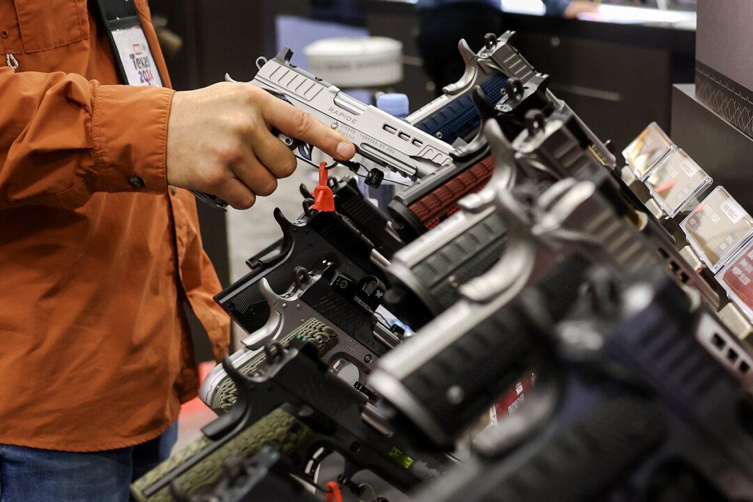 A visitor inspects a gun at the National Rifle Association Annual Meeting & Exhibits at the Kay Bailey Hutchison Convention Center in Dallas on May 17, 2024. (Justin Sullivan/Getty Images)