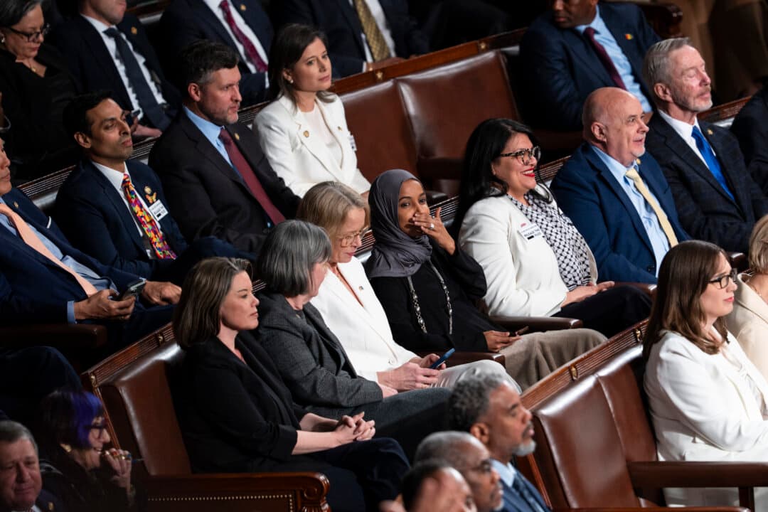 Rep. Ilhan Omar (D-Minn.) and Rep. Rashida Tlaib (D-Mich.) and other Democratic lawmakers react during the speech. (Madalina Kilroy/The Epoch Times)
