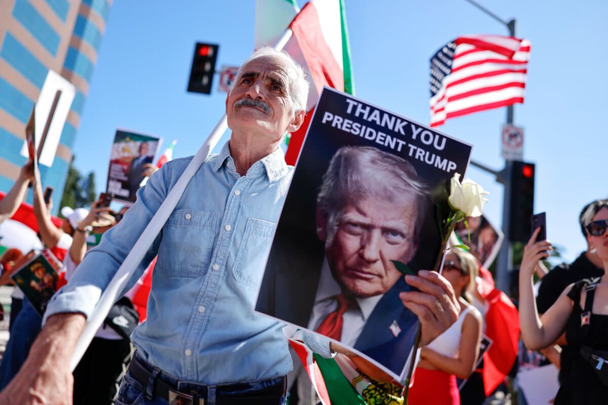 A man holds a picture of President Donald Trump as members of the Iranian community and supporters celebrate the U.S. and Israel attack on Iran, in Los Angeles on Feb. 28, 2026. (Mario Tama/Getty Images)