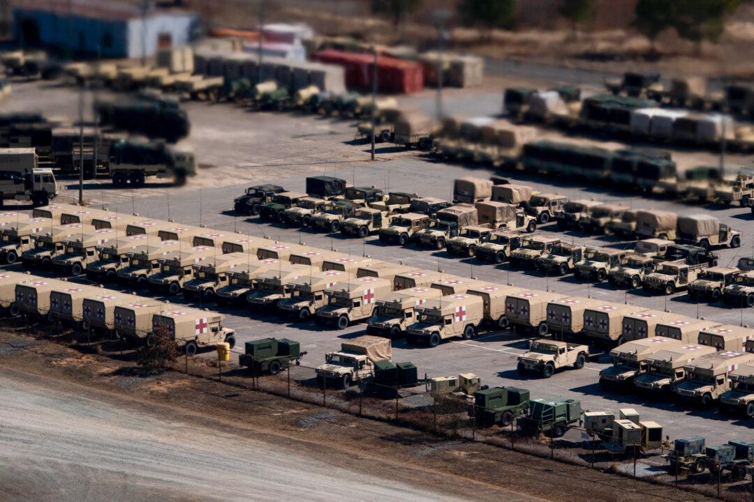 (Top) U.S. Army Col. Scott D. Wilkinson delivers a message to members of the 2nd Brigade Combat Team of the 101st Airborne Division prior to their departure for Europe in Fort Campbell, Ky., on July 6, 2022. (Bottom Left) Military vehicles are seen from Air Force One at Fort Bragg in Fort Bragg, N.C., on Feb. 13, 2026. (Bottom Right) A member of the U.S. Army 4th Infantry Division hoists an American flag onto his tank while participating in the NATO Iron Wolf military exercises in Pabrade, Lithuania, on Oct. 26, 2022. (Brett Carlsen/Getty Images, Nathan Howard/Getty Images, Sean Gallup/Getty Images)