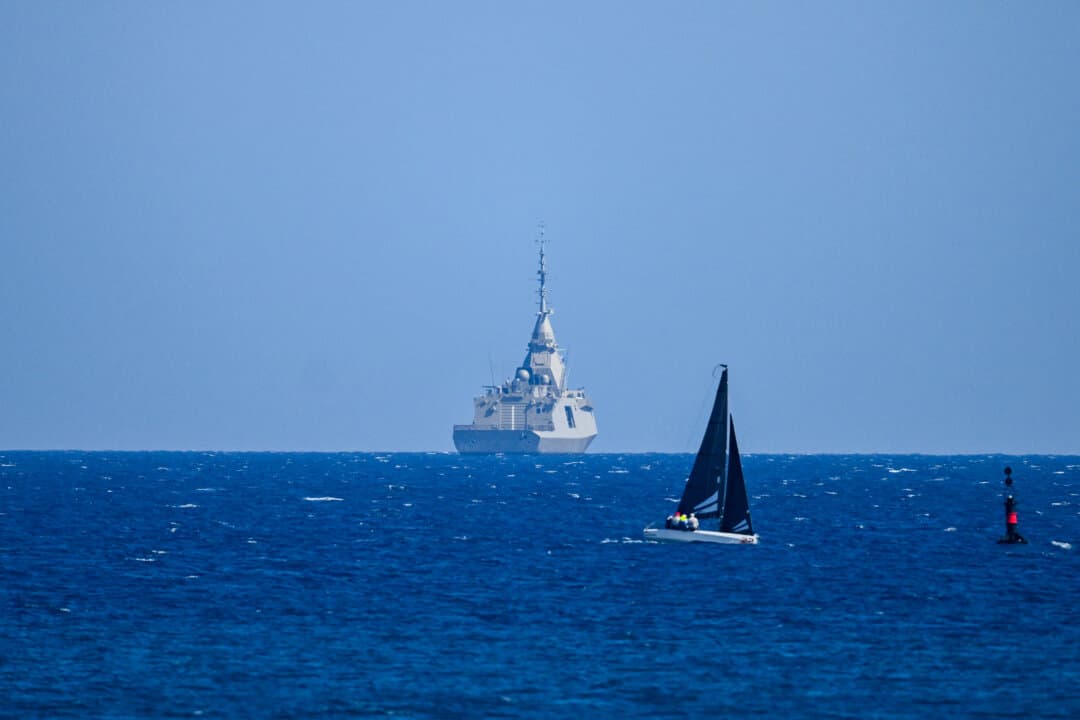 A sailboat passes the Greek frigate Keimon at sea off Limassol on March 4, 2026. France will deploy anti-missile and anti-drone systems to Cyprus, the Mediterranean island's government said on March 3, following an Iranian drone attack on a British base. (Jewel Samad/AFP via Getty Images)