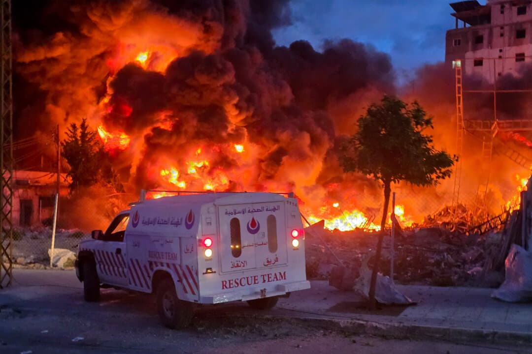 An ambulance is parked near a sweeping blaze following Israeli bombardment of a solar farm and electricity generation facility in Tyre, Lebanon, on March 4, 2026. Israeli forces advanced into a number of towns and villages in south Lebanon, a source from the United Nations peacekeeping force in the country told AFP. (Kawnat Haju/AFP via Getty Images)