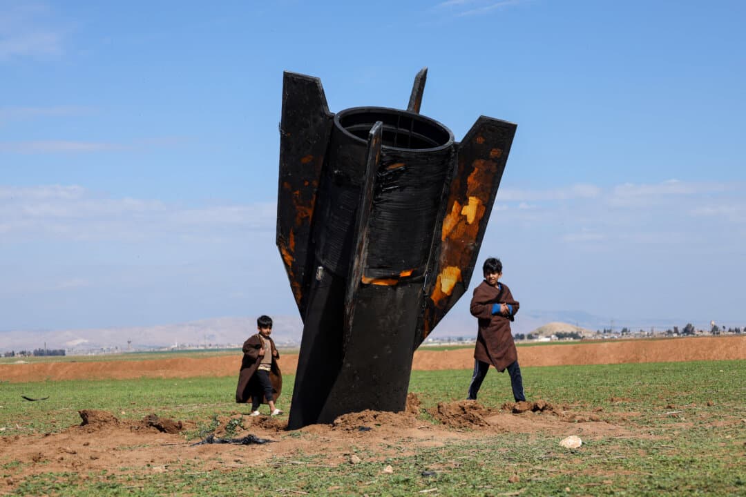 Kids walk around an Iranian missile after it fell near Qamishli International Airport near the Turkish border in Hasakah, Syria, on March 4, 2026, amid the U.S.-Israeli conflict with Iran. (Amjad Kurdo/Middle East Images/AFP via Getty Images)