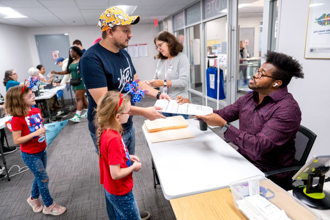 A voter gets instructions on where to go as he gets ready to cast his early vote at a polling station in Arlington, Va., on Sept. 20, 2024. (AFP via Getty Images)