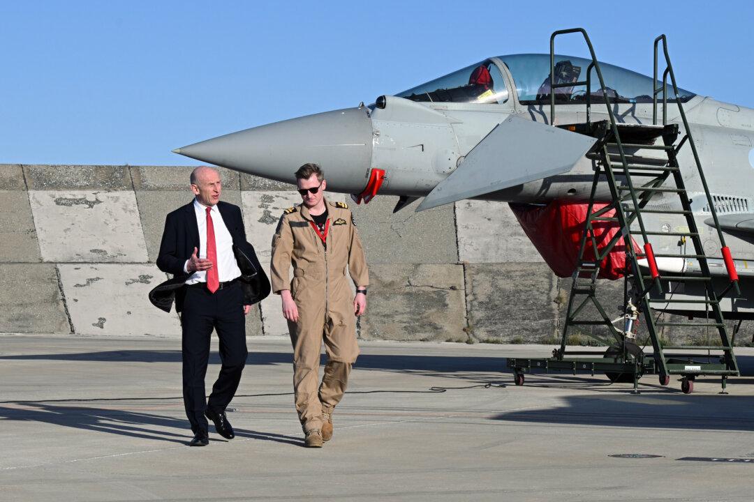 UK Defense Secretary John Healey meets the RAF pilot who shot down a drone as they walk past British typhoon and F-35 jets at RAF Akrotiri in Cyprus, on March 5, 2026. The visit comes days after the British airbase was targeted by Iranian drones. (Leon Neal/Getty Images)