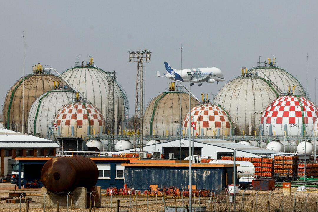 An Airbus Beluga transport airliner flies over storage tanks at a liquefied petroleum gas factory in Pinto, near Madrid, on March 5, 2026. Markets have roiled much of the week as the conflict between the United States and Iran effectively closed shipping through the Strait of Hormuz. (Oscar Del Pozo/AFP via Getty Images)