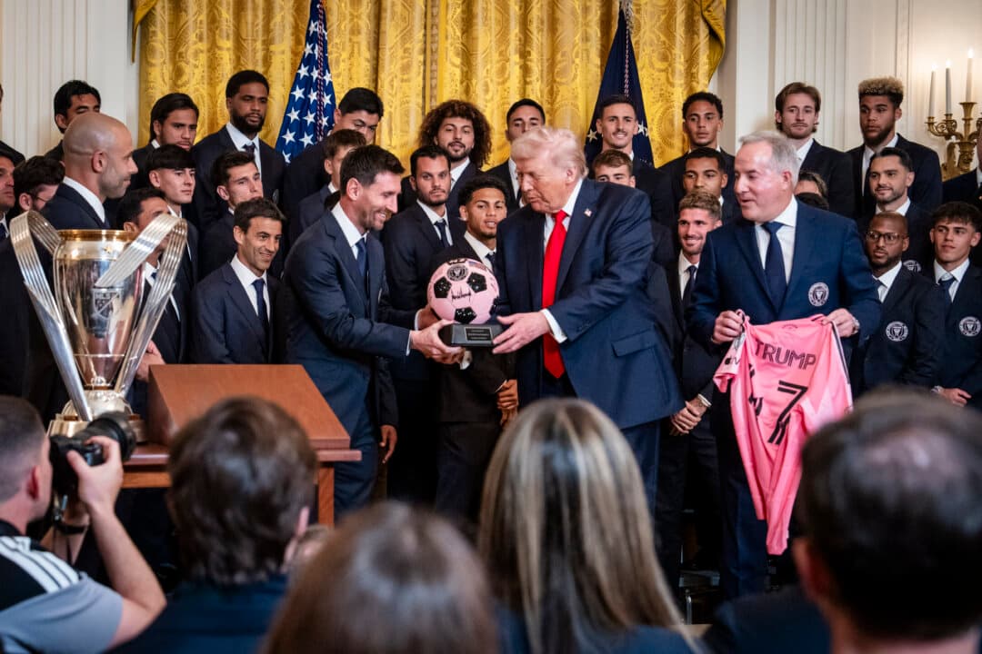 President Donald Trump receives gifts from Inter Miami CF CEO and Managing Owner Jorge Mas (R) and Lionel Messi (L) of Inter Miami CF during an event celebrating the 2025 MLS Cup Champions at the White House on March 5, 2026. (Madalina Kilroy/The Epoch Times)