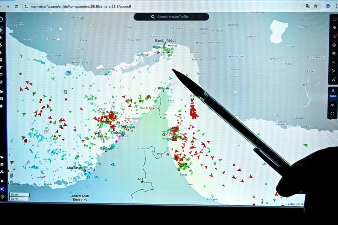 A person points at a page on the Marinetraffic website that shows commercial boat traffic on the edge of the Strait of Hormuz near the Iranian coast amid the ongoing war in the Middle East, in Paris on March 4, 2026. (Julien De Rosa/AFP via Getty Images)
