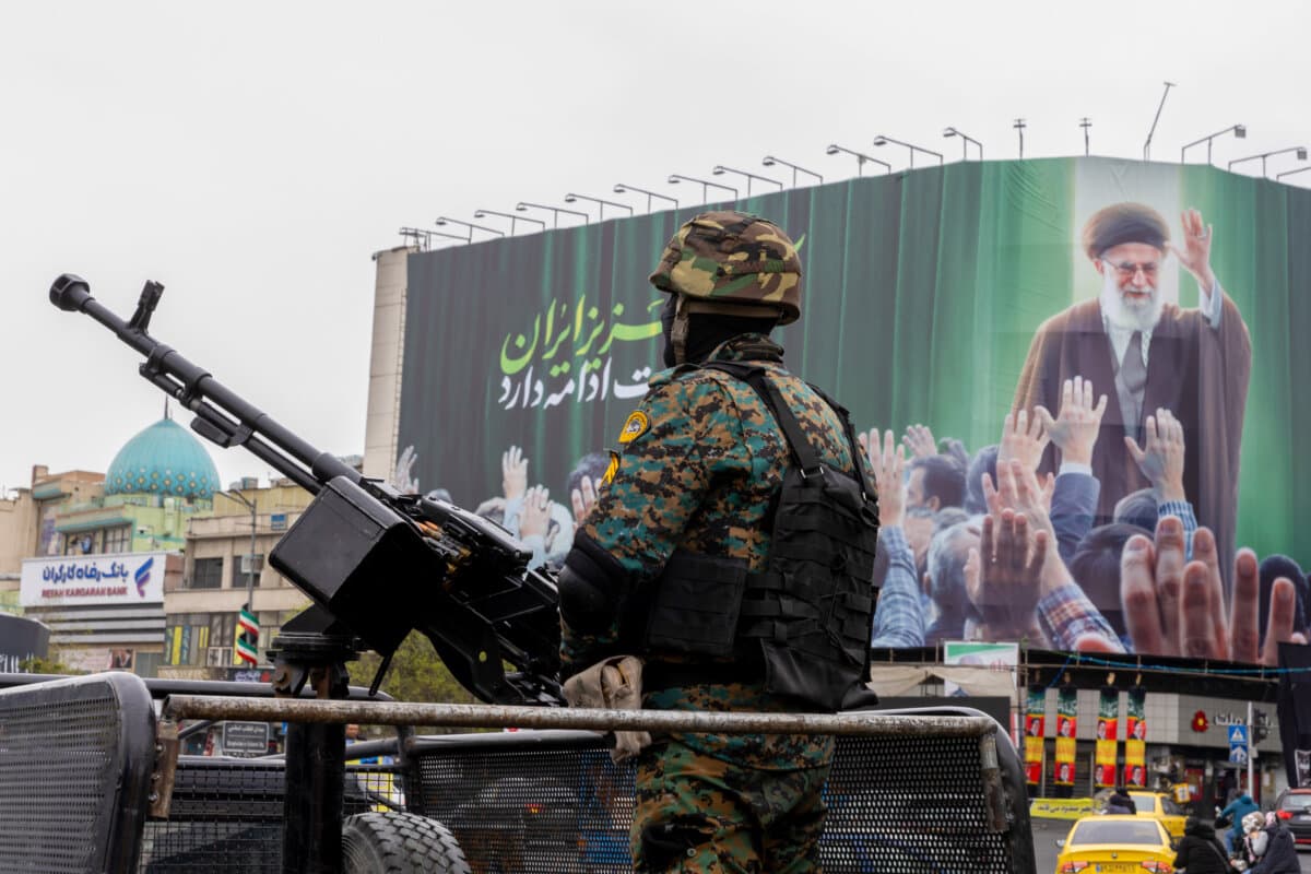 A police officer stands guard beneath a poster of Iran's former leader, Ayatollah Ali Khamenei, in Tehran, Iran, on March 10, 2026. (Majid Saeedi/Getty Images)