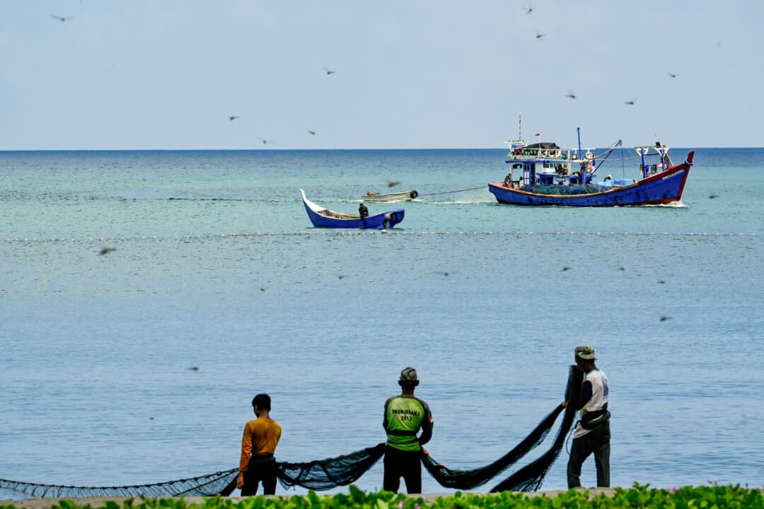 Fishermen pull a net at a beach in Banda Aceh, Indonesia, on March 12, 2026. (Chaideer Mahyuddin/AFP via Getty Images)