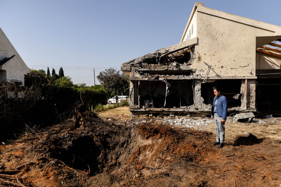 A woman looks at the impact of a missile strike after Hezbollah and Iran launched coordinated barrages on northern and in Haniel, Israel, on March 12, 2026. Iran has continued firing waves of drones and missiles at Israel after the United States and Israel launched a joint attack on Iran early on Feb. 28. (Amir Levy/Getty Images)