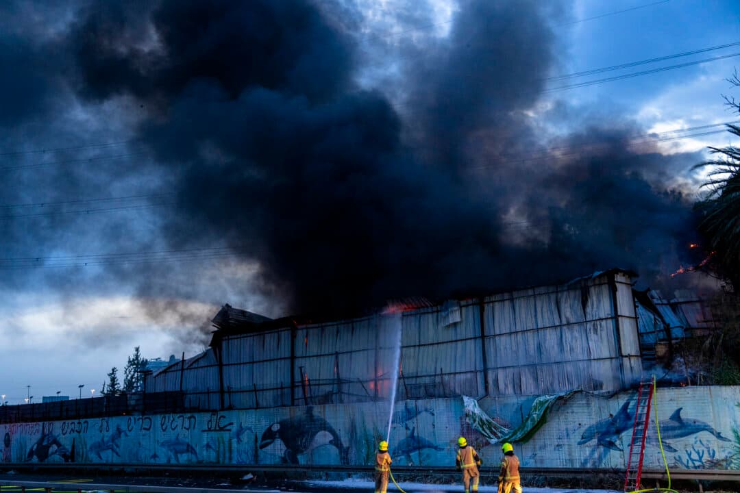 Firefighters try to extinguish a warehouse blaze that occurred amid a barrage of Iranian missiles in Holon, Israel, on March 13, 2026. The warehouse appeared to have been struck by parts of a projectile after its interception. Iran has continued to launch waves of drones and missiles at Israel after the Feb. 28 U.S.-Israeli-led air strikes on Iran. (Erik Marmor/Getty Images)