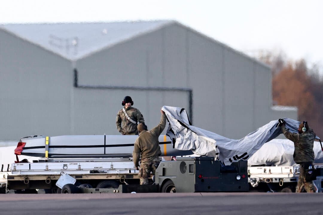 USAF military personnel work on AGM-158 joint air-to-surface standoff cruise missiles, near a U.S. Air Force B-1 Lancer bomber jet, on the tarmac after it landed at RAF Fairford in southwest England on March 13, 2026. Fairford is one of two bases, along with Diego Garcia in the Indian Ocean, that the UK has given the United States permission to use for specific defensive operations into Iran to destroy Iranian missiles at source, the British defense minister said in a statement. (Henry Nicholls/AFP via Getty Images)