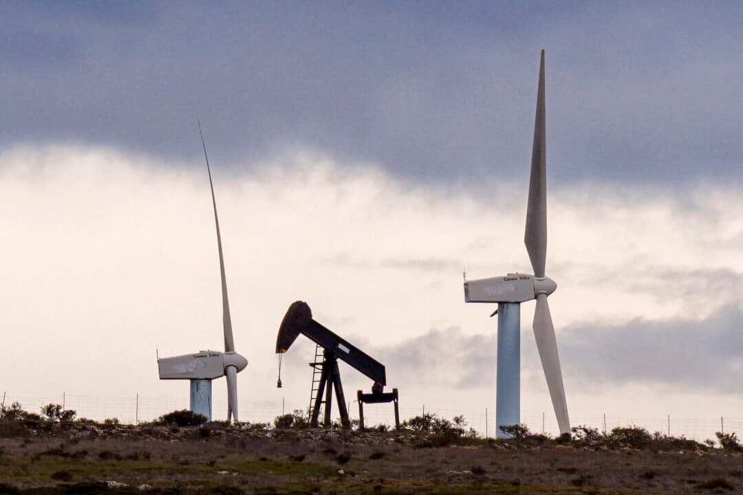 An oil pump at an obsolete oilfield, with wind turbines in the background, in Sargentes de la Lora, near Burgos in northern Spain, on March 13, 2026. Spain's leftist government yesterday said it would soon present a plan to contain the Middle East war's impact on electricity and fuel prices in one of the most dynamic developed economies. (Cesar Manso/AFP via Getty Images)