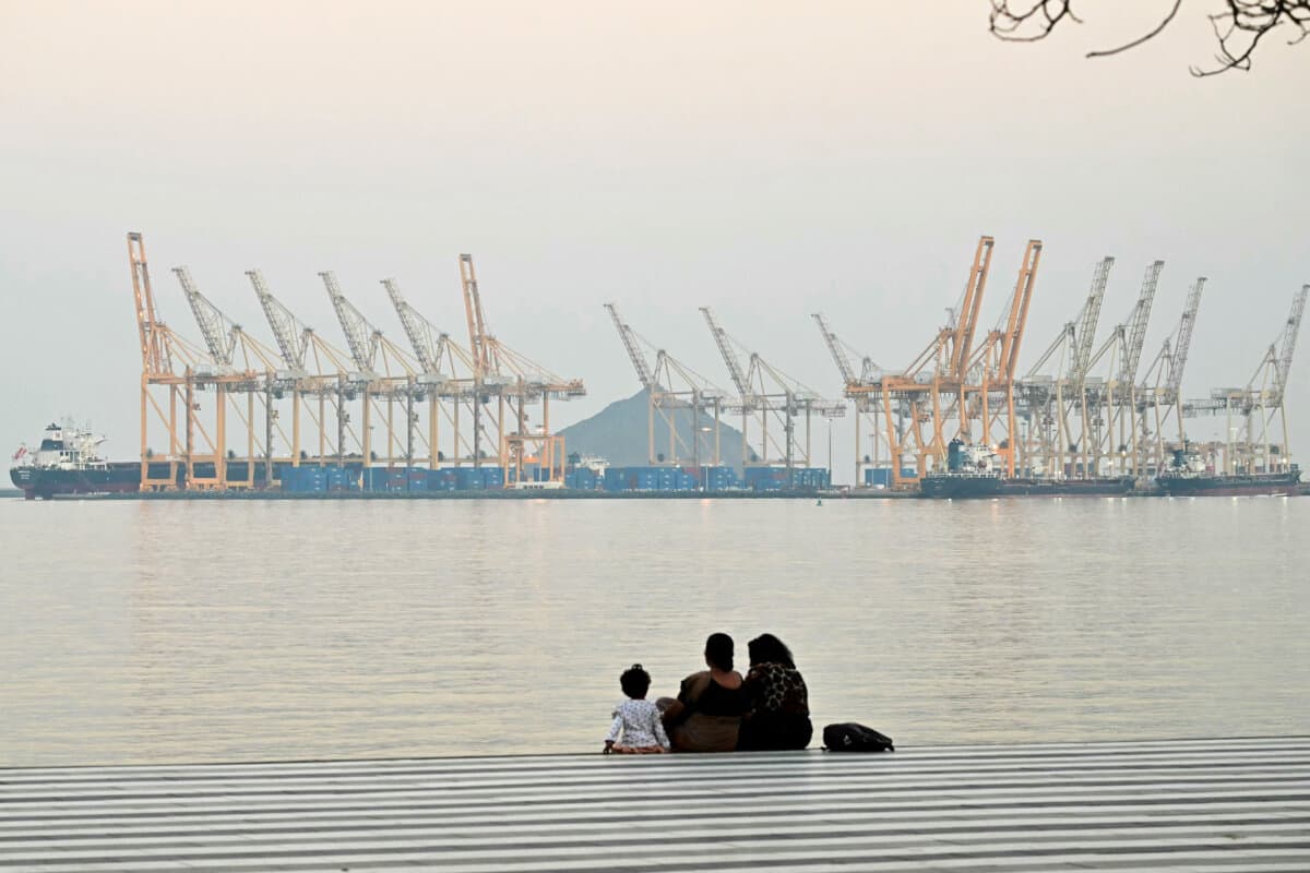 A family views a dockyard off the city of Fujairah, United Arab Emirates, just south of the Strait of Hormuz, on Feb. 25, 2026. (Giuseppe Cacace/AFP via Getty Images)