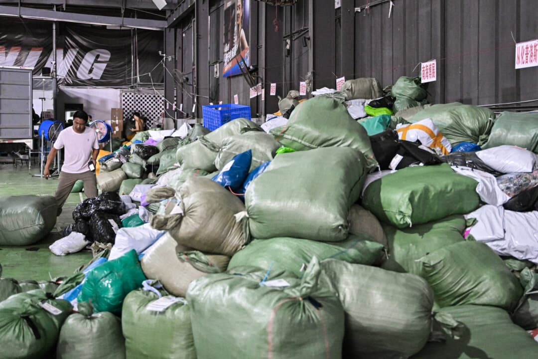 A man works at a warehouse of the Weijiang International delivery company, which works with packages from Chinese-founded online shopping giant, Temu, in Guangzhou, Guangdong province, China, on Aug. 12, 2025. (Adek Berry/AFP via Getty Images)