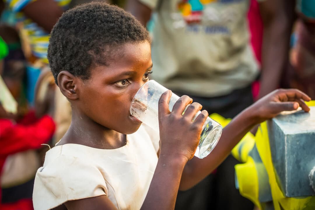 (Top Left) A water well built by Water Wells for Africa, donated by actor Charlie Sheen, continues operation in southern Malawi on June 30, 2021. (Top Right–Bottom Left) Villagers enjoy clean water from a well built by Water Wells for Africa on July 6, 2018. (Bottom Right) A water well funded by stuntman Eddie Braun sits in operation in southern Malawi on June 7, 2023. (John Fredricks/The Epoch Times)