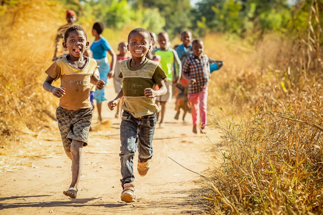 Children run to a water well built by Water Wells for Africa in southern Malawi on June 14, 2019. Kurt Dahlin said that the wells improve health and support agriculture while reducing the need to fetch water, allowing more children—especially girls—to attend school. (John Fredricks/The Epoch Times)