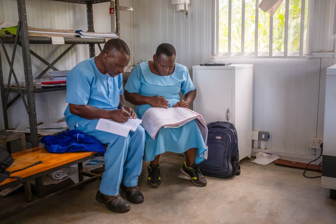 Health Surveillance Officers Duncan Chikwindile (L) and Madalenji Panjima look through Cholera records at a clinic in the rural Blantyre district, Malawi, on Feb. 23, 2026. (John Fredricks/The Epoch Times)