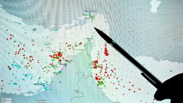 A person points at a page on the MarineTraffic website that shows commercial shipping traffic on the edge of the Strait of Hormuz near the Iranian coast on March 4, 2026. (Julien de Rosa/AFP via Getty Images)