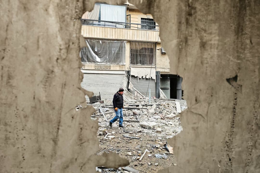 A man walks along a street strewn with building debris at the site of an overnight Israeli airstrike that targeted a neighborhood in the southern suburbs of Beirut, Lebanon, on March 25, 2026. Lebanon was pulled into the Middle East war when Iran-backed Hezbollah terrorist group began firing rockets into Israel on March 2 to avenge the killing of Iran's supreme leader. (AFP via Getty Images)