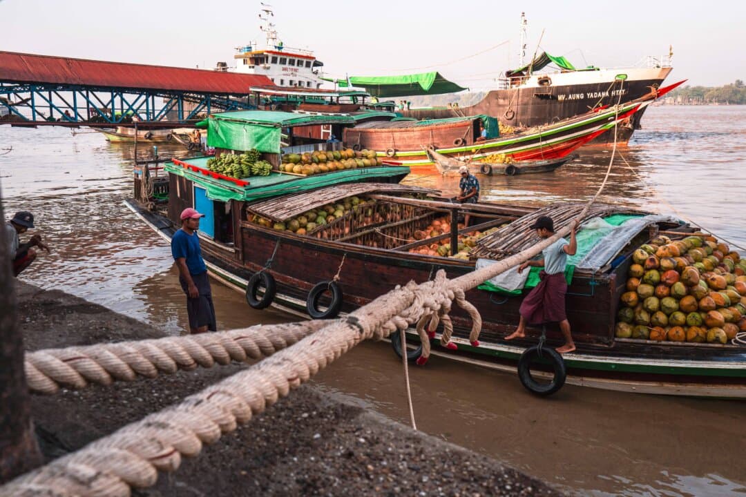 Workers prepare to deliver bananas and coconuts to a wholesale market in Yangon, Burma, on March 25, 2026. (Anthony Wallace/AFP via Getty Images)