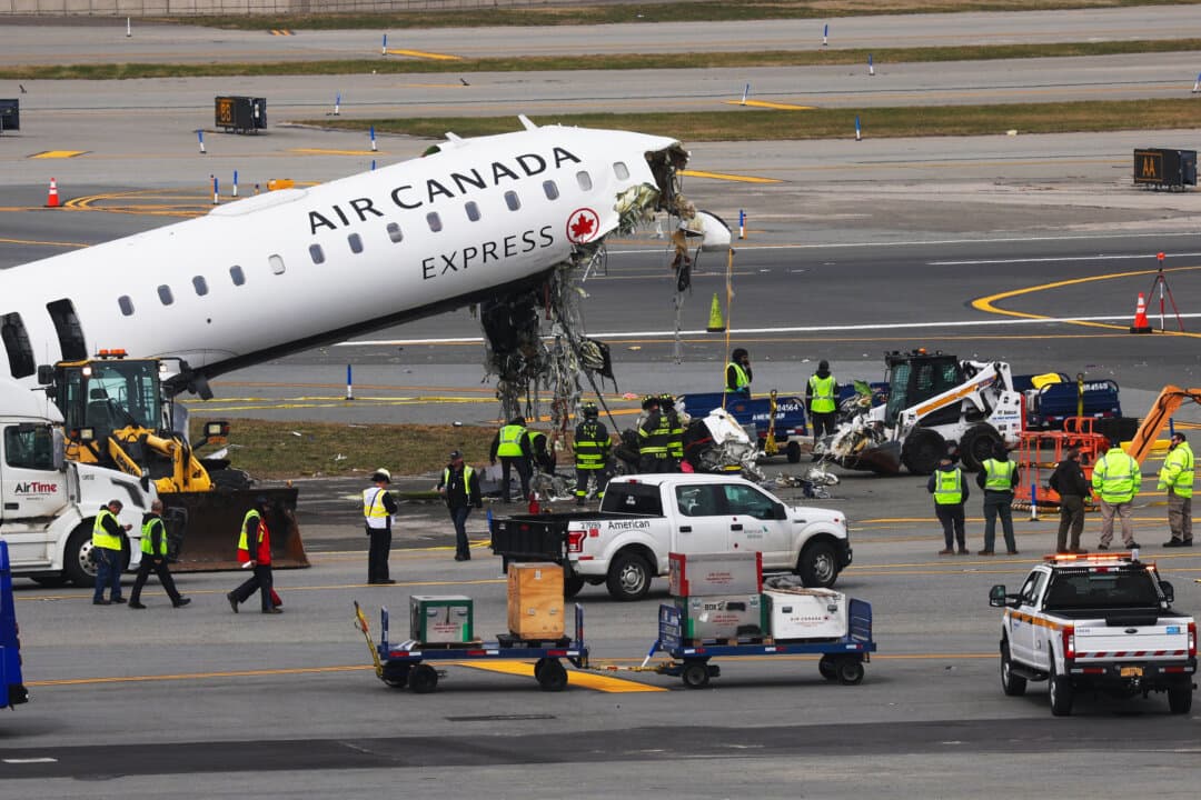Officials investigate after an Air Canada Express plane collided with a fire truck on the tarmac at LaGuardia Airport in New York City on March 25, 2026. The plane had landed from a flight from Montreal when it collided with a fire truck, resulting in the deaths of two pilots and injuring dozens. (Spencer Platt/Getty Images)