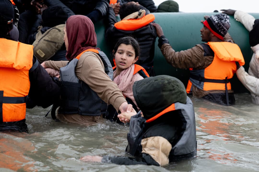 Migrants prepare to board a dinghy before attempting to sail into the English Channel in Gravelines, France, on April 1, 2026. (Tom Nicholson/Getty Images)