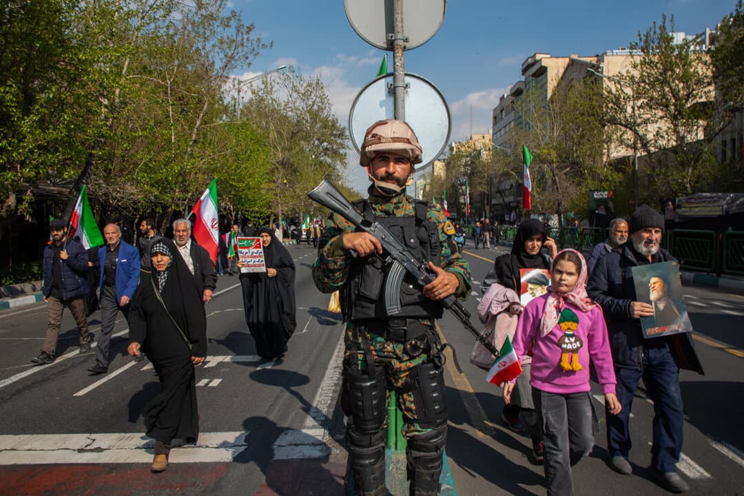 A member of the Iranian security services stands guard as a funeral procession is held for Navy Chief Alireza Tangsiri, alongside other senior naval commanders and their families who were killed in U.S.–Israeli strikes in late March, in Tehran, Iran, on April 1, 2026. (Majid Saeedi/Getty Images)