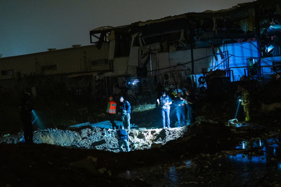 Emergency crews inspect a crater where an Iranian ballistic missile struck an industrial area in Petah Tikva, Israel, on April 2, 2026. (Erik Marmor/Getty Images)