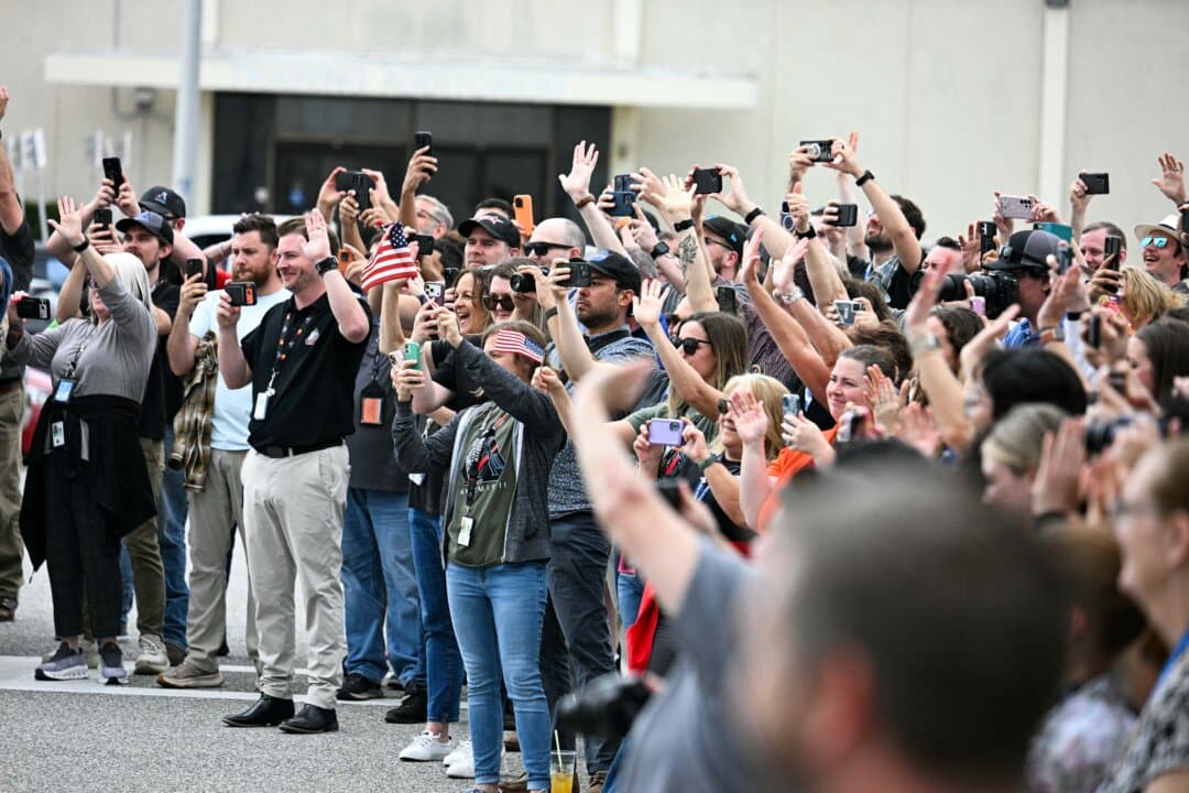 Loved ones and colleagues wave to the Artemis II mission crew as they walk out before traveling to the launch pad to board the Space Launch System rocket for the Artemis II crewed lunar mission at Kennedy Space Center in Cape Canaveral, Fla., on April 1, 2026. Three men and one woman are set to embark on the first crewed journey to the moon since 1972, a landmark odyssey that aims to launch the United States into a new era of space exploration. (Jim Watson/AFP via Getty Images)