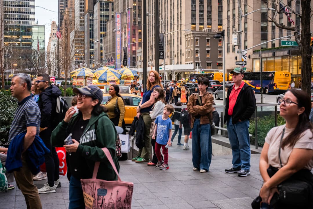 People watch the Artemis II crewed lunar mission launch on televisions outside of the News Corp building in New York City on April 1, 2026. The 10-day mission will take NASA astronauts Commander Reid Wiseman, Pilot Victor Glover, and Mission Specialist Christina Koch, and Canadian Space Agency Mission Specialist Jeremy Hansen around the moon and back. The astronauts are supposed to fly 230,000 miles out into space, the farthest any human has ever traveled from Earth. (Adam Gray/Getty Images)