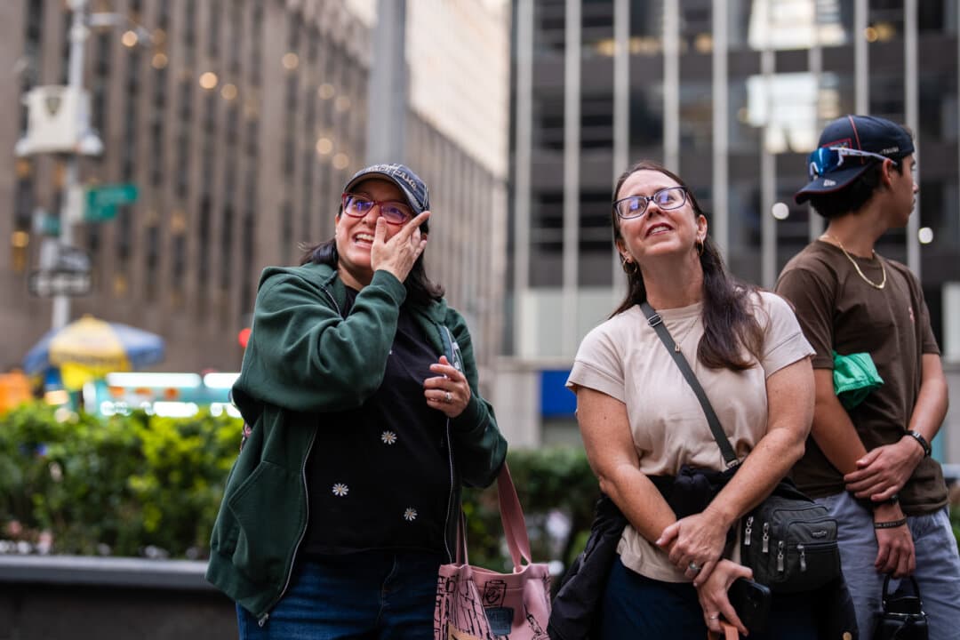 People react as they watch the Artemis II crewed lunar mission launch on televisions outside of the News Corp building in New York City on April 1, 2026. (Adam Gray/Getty Images)