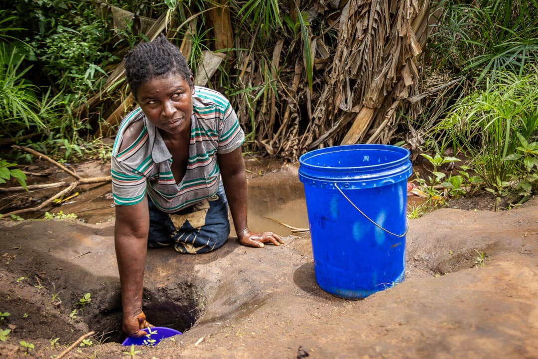 A woman collects water in the Mangochi District of Malawi on Feb. 20, 2026. (John Fredricks/The Epoch Times)