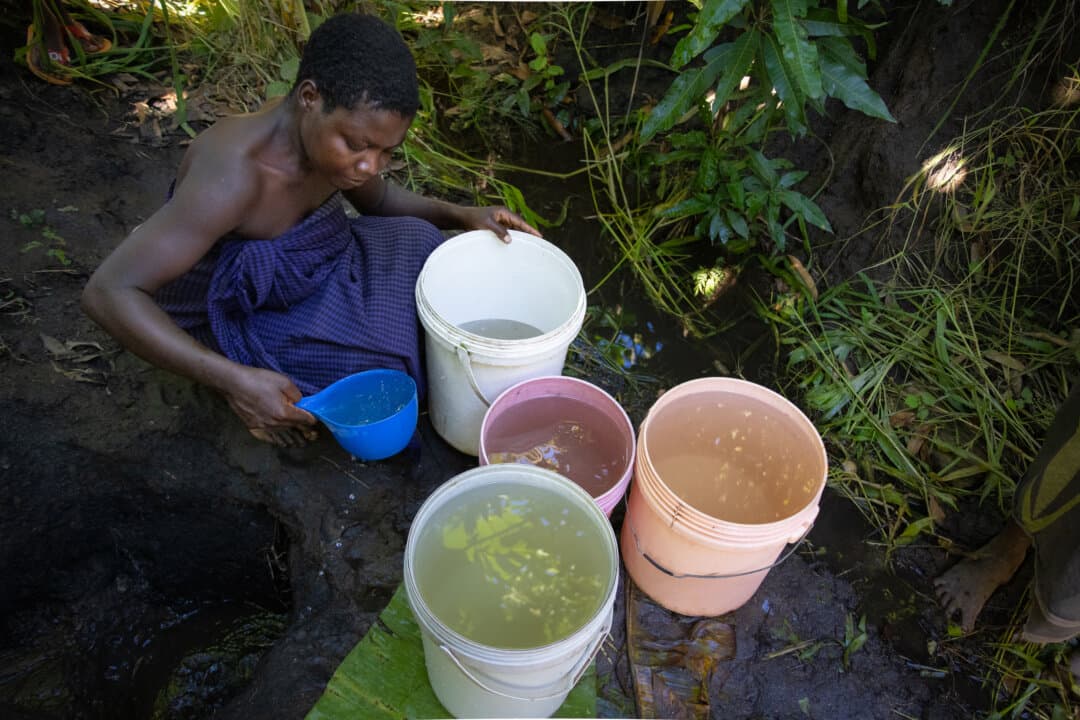 A woman collects water in the Blantyre Rural District, Malawi, on Feb. 23, 2026. (John Fredricks/The Epoch Times)