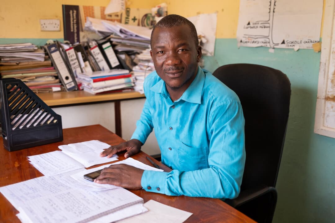 Senior Health Surveillance Assistant Robert Amissi sits near medical records outside of Monkey Bay, Malawi, on Feb. 18, 2026. (John Fredricks/The Epoch Times)