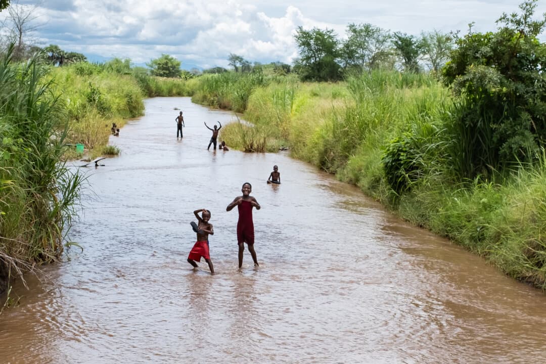 Children play in a river outside of Monkey Bay, Malawi, on Feb. 18, 2026. (John Fredricks/The Epoch Times)
