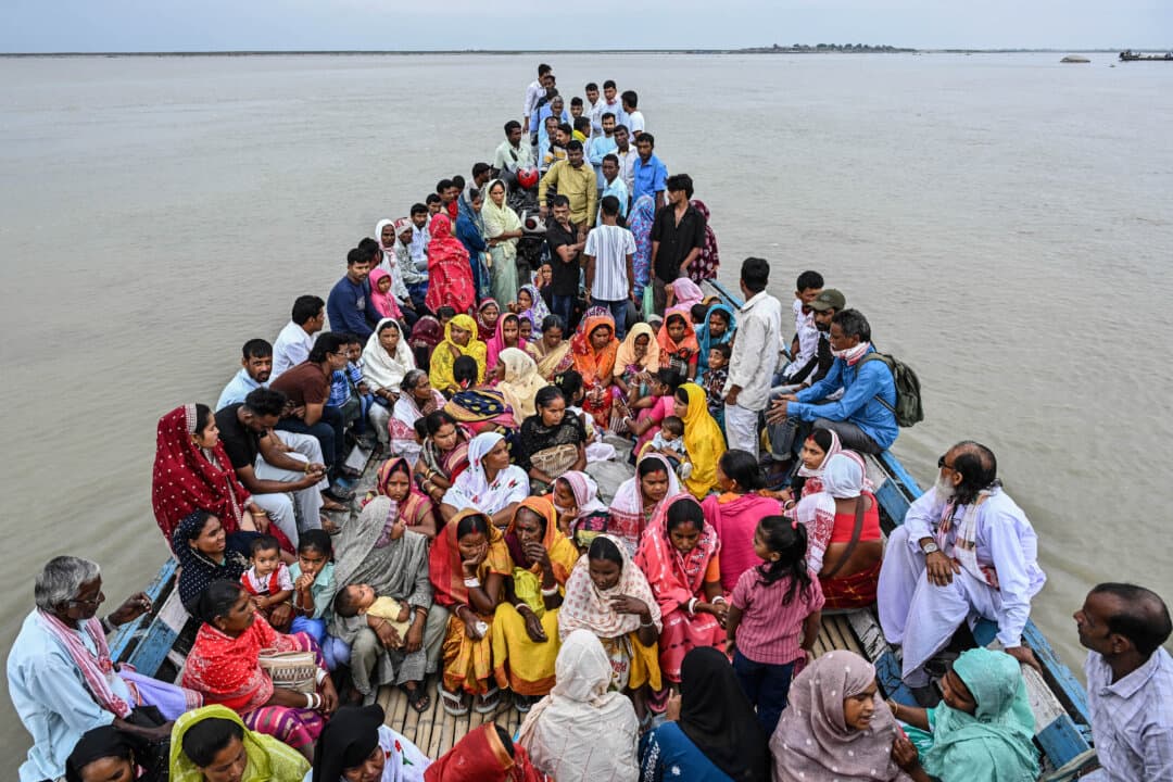 People travel on a boat across the Brahmaputra River to cast their ballots to vote at a polling booth during the Assam Legislative Assembly election in the Darrang district, India, on April 9, 2026. (Biju Boro/AFP via Getty Images)