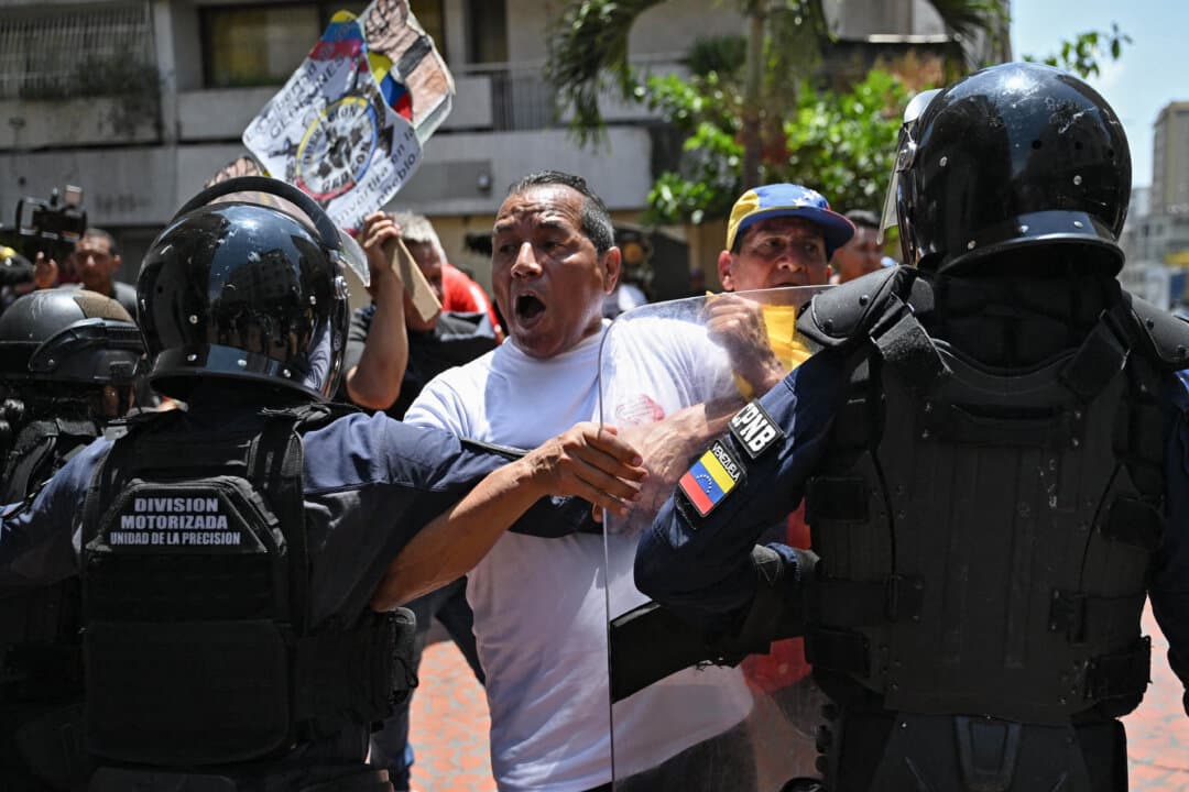 An opponent to the government of Venezuelan interim President Delcy Rodríguez clashes with the police as he demonstrates in demand of salary and pension raises in Caracas, Venezuela, on April 9, 2026. (Juan Barreto/AFP via Getty Images)