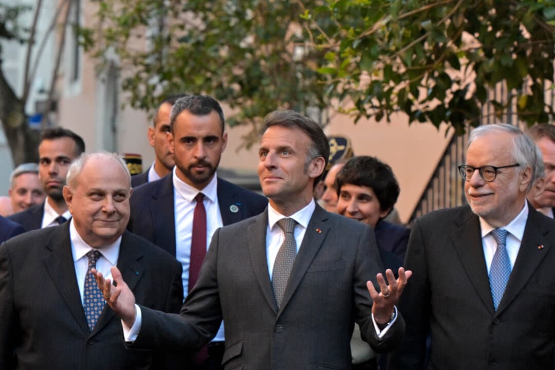 French President Emmanuel Macron (C) walks in Trastevere neighborhood with the founder of the Catholic charity Sant'Egidio community, Andrea Riccardi (R), in Rome on April 9, 2026. (Tiziana FABI/AFP via Getty Images)