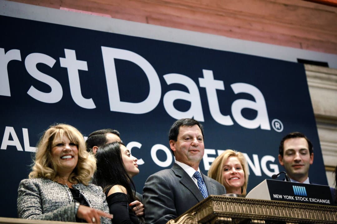 First Data CEO Frank Bisignano (C) looks around the New York Stock Exchange after ringing the opening bell to mark the company’s $2.56 billion initial public offering in New York City on Oct. 16, 2015. Bisignano led the company through a period of slow growth and heavy debt and later played a key role in its merger with Fiserv. (Yana Paskova/Getty Images)