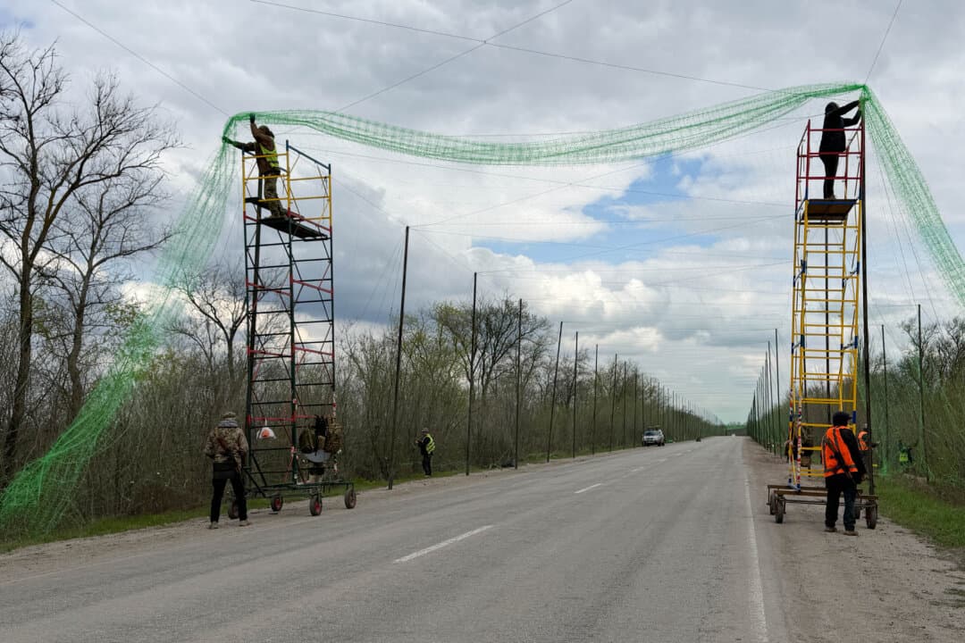 Ukrainian servicemen cover the road with a net to protect vehicles from drone attacks at an undisclosed location in the Zaporizhzhia region, Ukraine, on April 10, 2026. (Darya Nazarova/AFP via Getty Images)